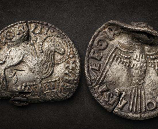 Obverse and reverse of the rare Anglo-Saxon Agnus Dei coin: the front shows the Lamb of God pierced by a cross and standing above the Alpha and Omega, while the reverse features the Holy Spirit dove.
