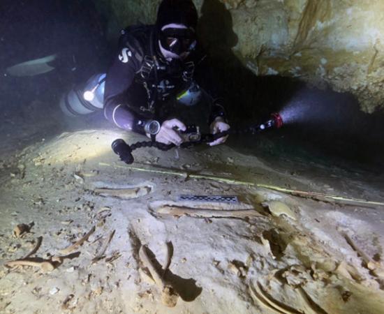 Underwater archaeologist Octavio del Río photographs the prehistoric skeleton discovered inside the flooded cave system in Actun, near Tulum, Mexico