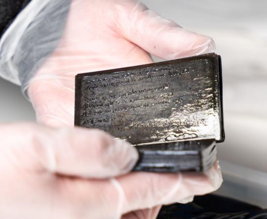 Researcher holding the 13th-14th century medieval wax notebook.